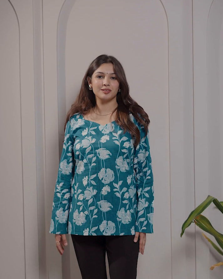 Woman wearing a blue floral top standing against a neutral background with text overlay.